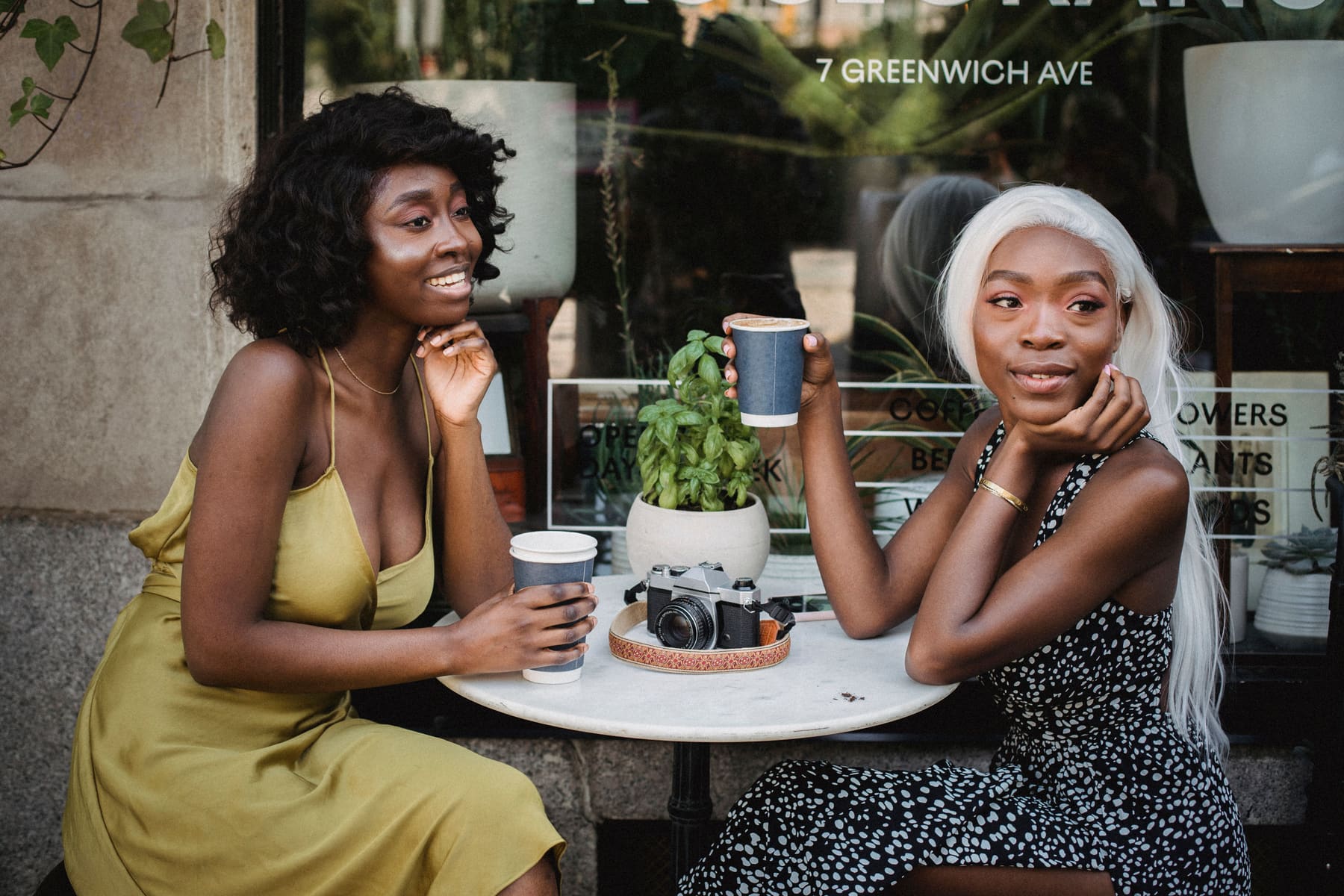 Two women talking over coffee at an outdoor café table